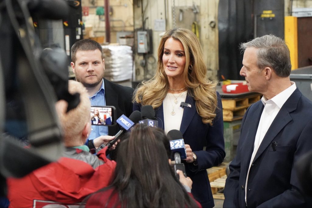 Administrator Loeffler speaks to members of the press while inside of a manufacturing small business